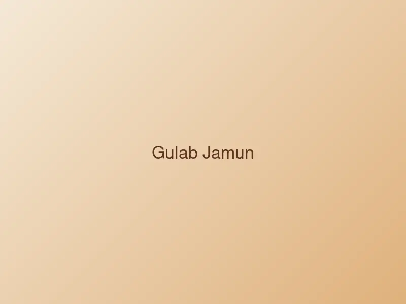 Two gulab jamun dumplings in golden syrup